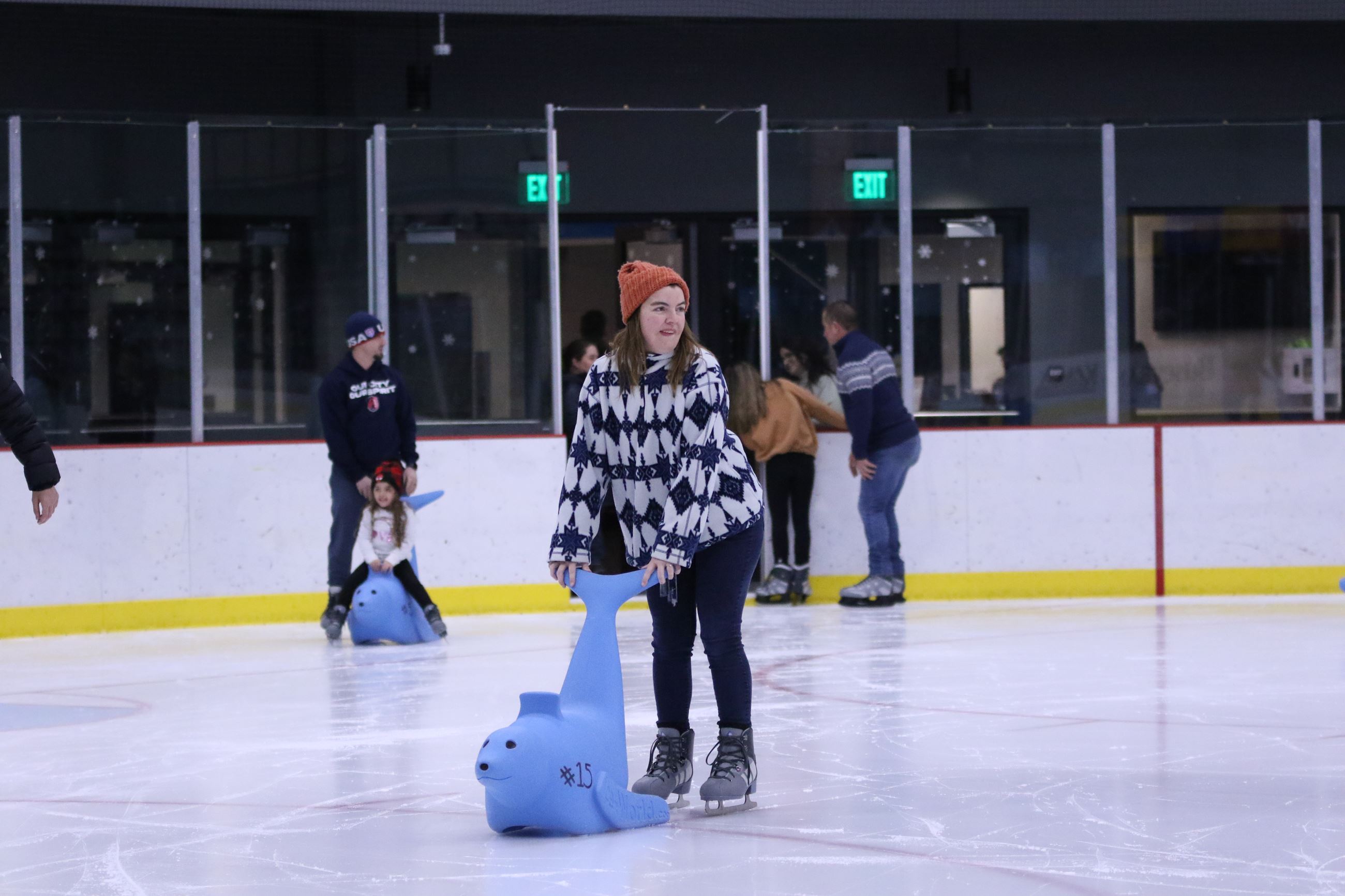 Skaters using a skate aid on a rink