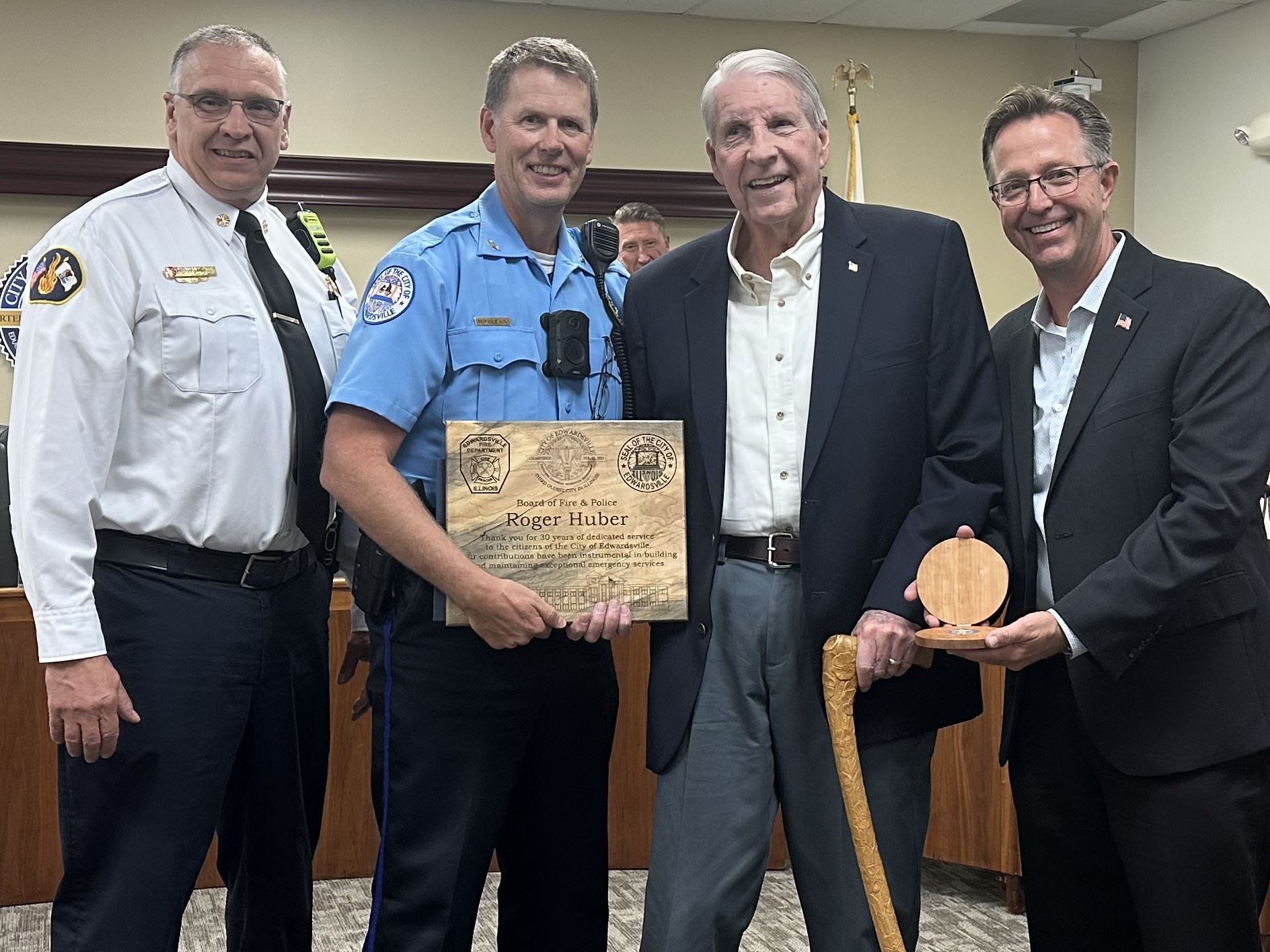 Four men pose for a photo with an award