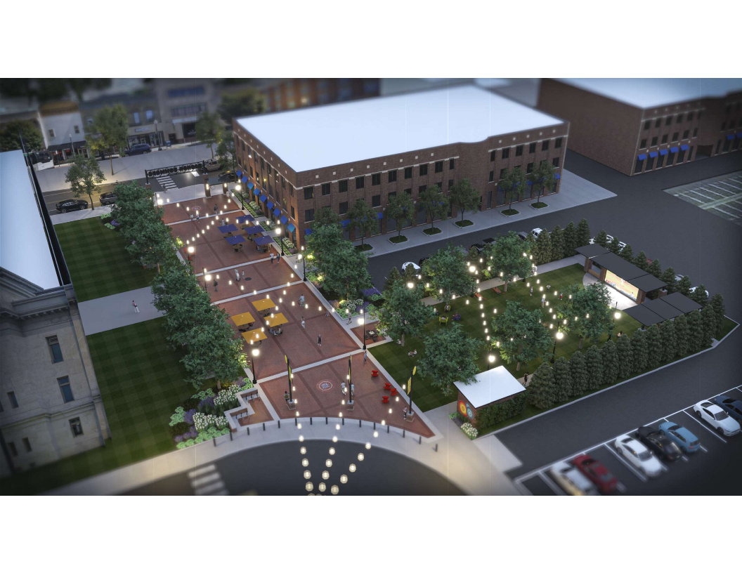 An overhead, nighttime view of a wide paved walkway next to a grassy park with overhead lighting